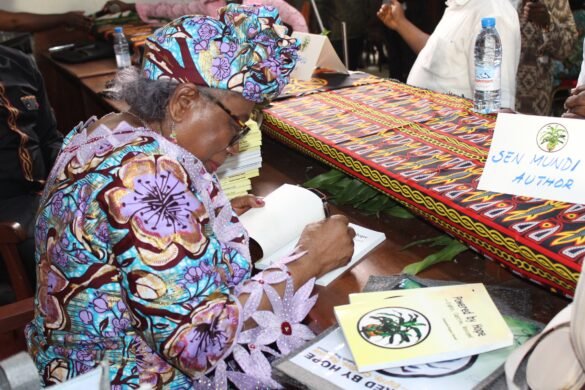 Senator Elizabeth Regina Mundi signing copies of her book after the launch