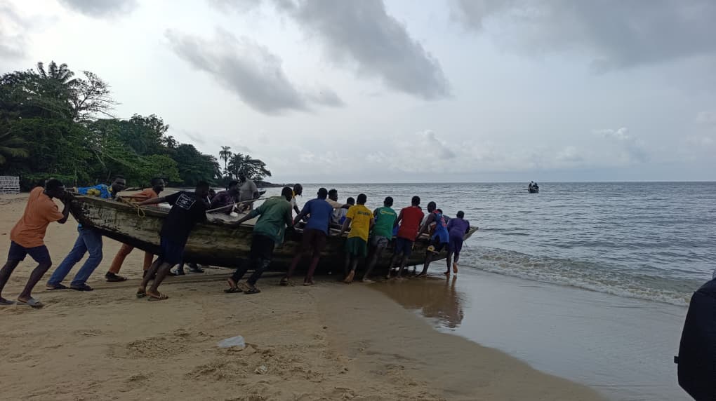 Fishermen pushing their wooden boat back to the sea for another catch (Image by Boris-Kaloff Batata)