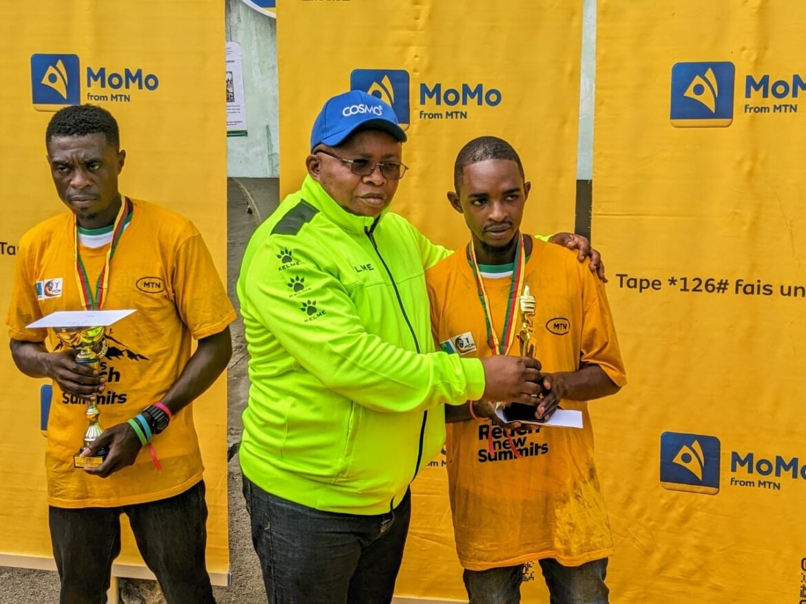 Test race champions Mofor Jeremiah receives trophy from Emmanuel Motomby Mbome, President Cameroon Athletics Federation