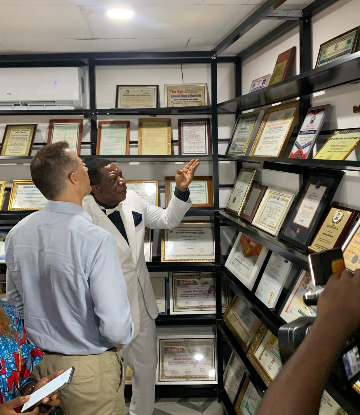 British High Commissioner, Matt Woods and Ntumfor, viewing awards at the Sir Dr Barrister Ntumfor Nico Halle Award Gallery in Bonaberi, Douala